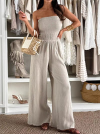 Smocked tube wide-leg jumpsuit in neutral color paired with stylish summer accessories.