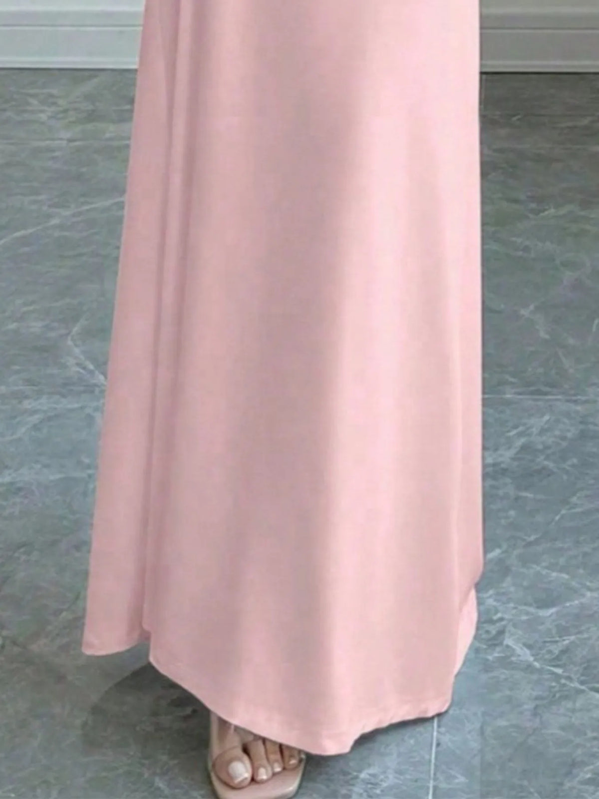 Close-up of the hem of a pink bodycon maxi dress, perfect for luxurious weddings and special occasions.