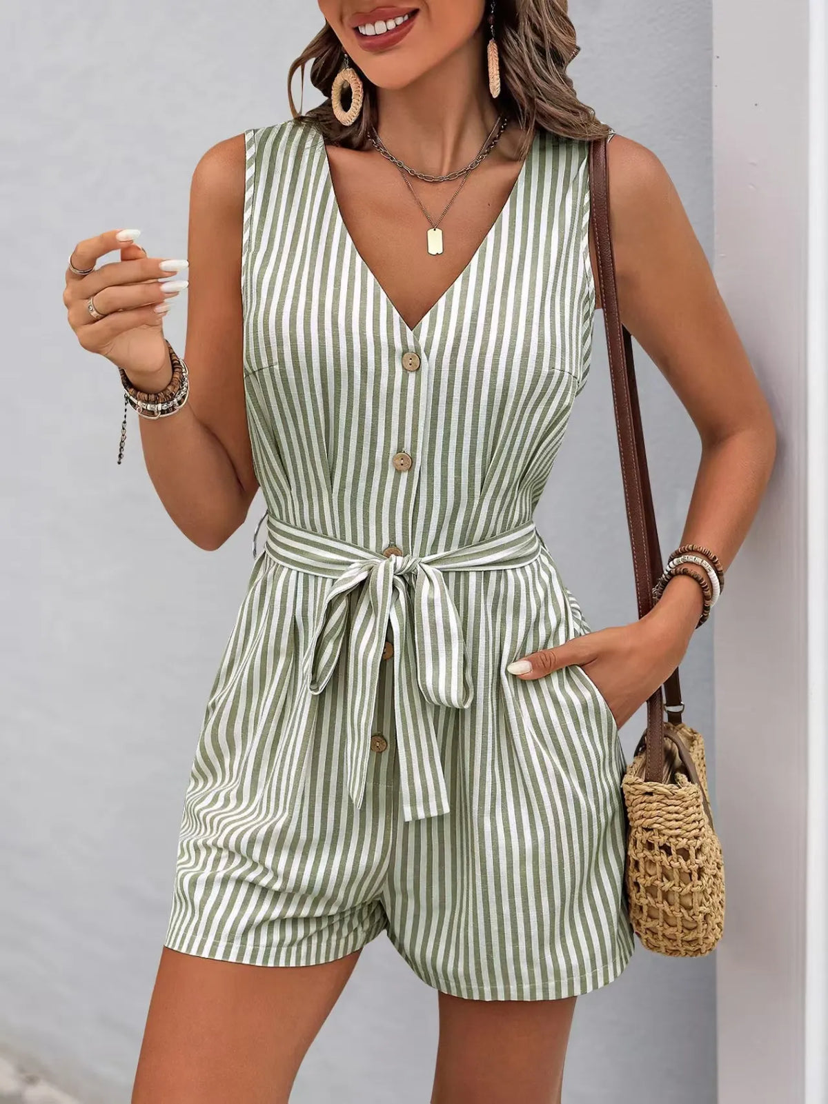 Striped V-neck button front belted romper in green, featuring practical pockets and a flattering silhouette.