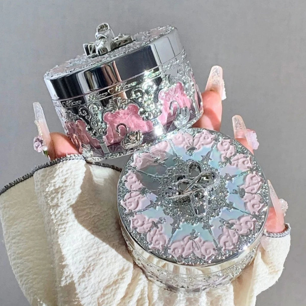a hand holding a pink and silver box