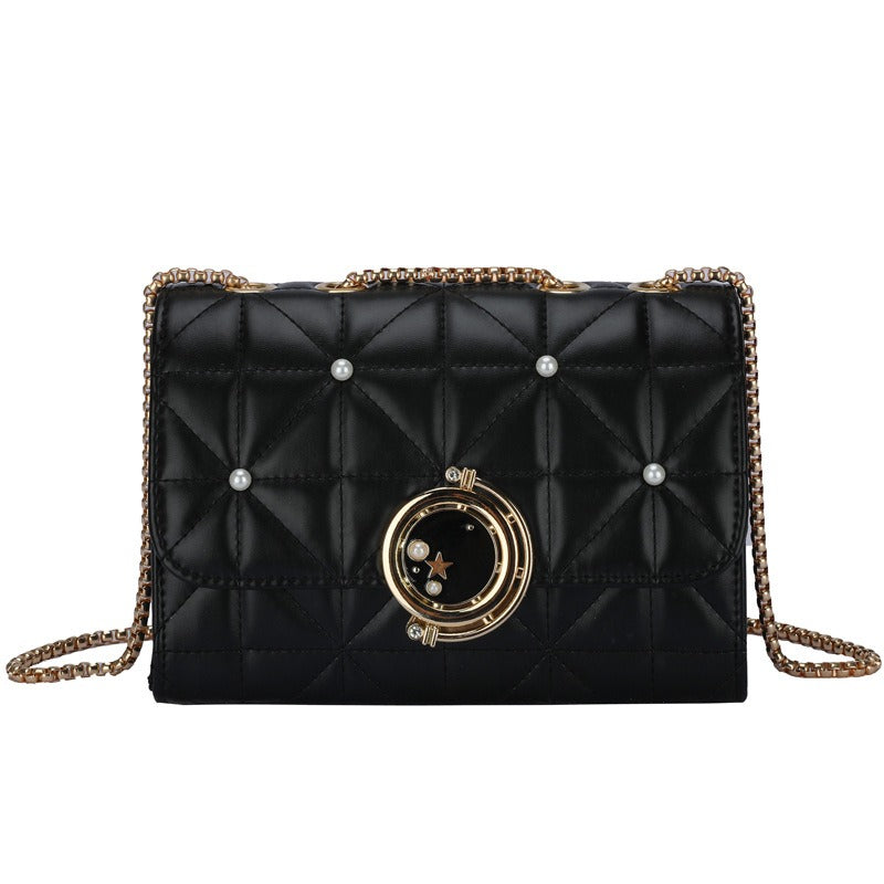 Elegant black leather crossbody bag with quilted design, gold accents, and pearls, perfect for luxurious weddings.