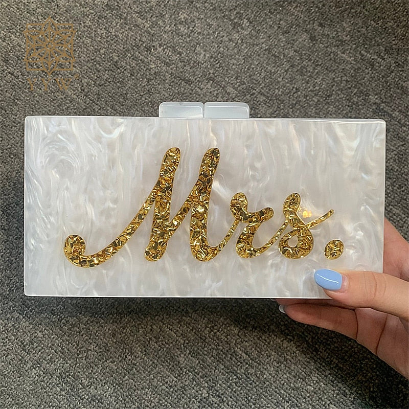 Handmade white marble evening bag with gold 'Mrs.' lettering, perfect for luxurious weddings and bridal parties.