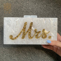 Handmade white marble evening bag with gold 'Mrs.' lettering, perfect for luxurious weddings and bridal parties.