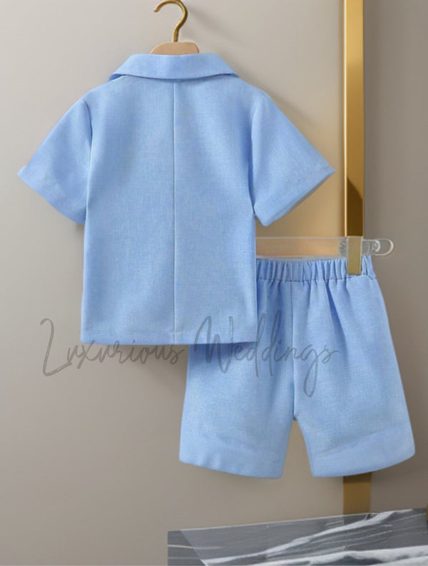 a baby boy's blue outfit hanging on a wall