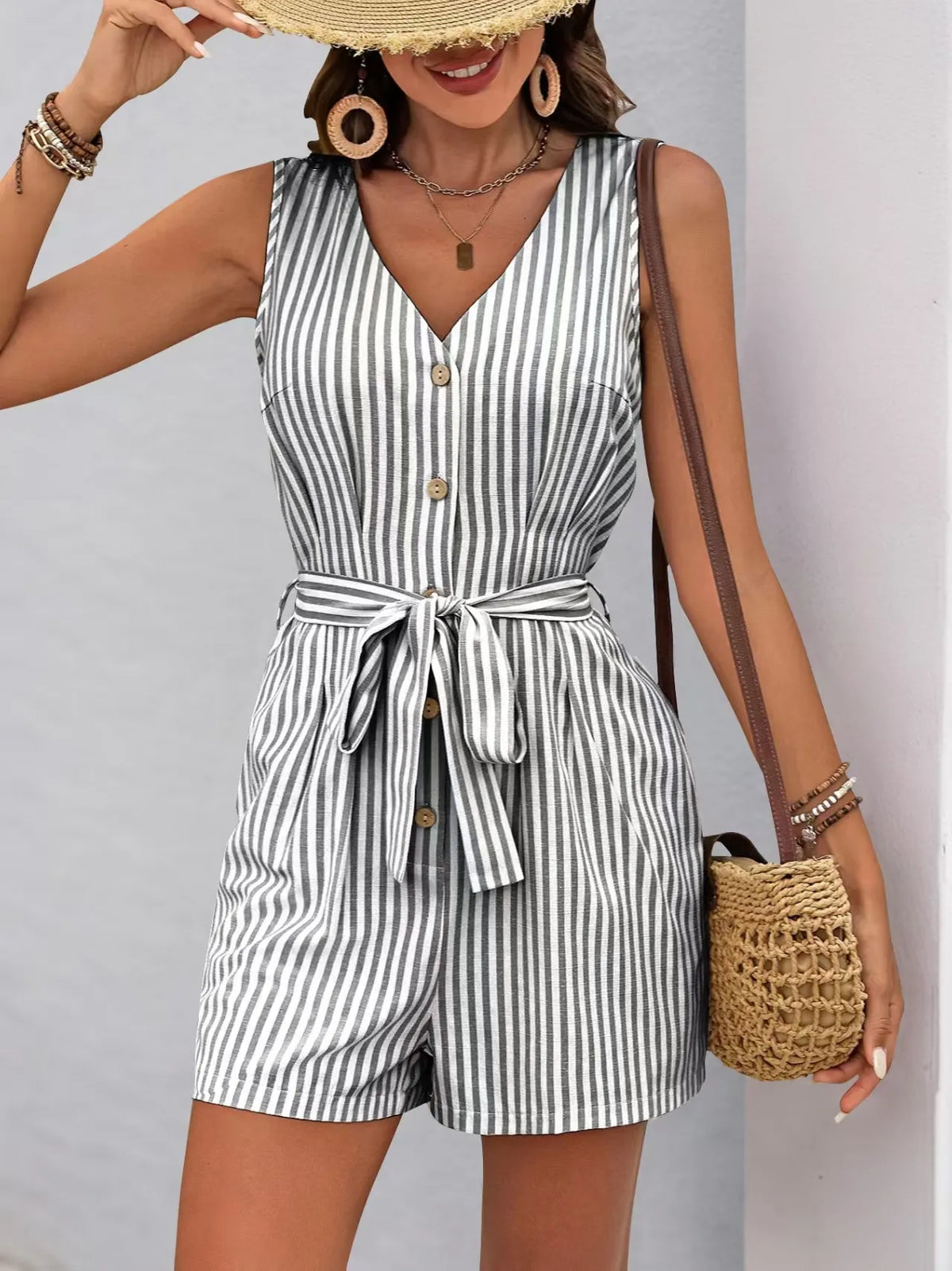 Striped V-neck belted romper featuring button front detail and pockets, perfect for summer styling.