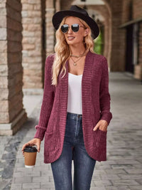 Woman wearing a maroon open front ribbed knit cardigan with pockets, sunglasses, and a coffee cup.