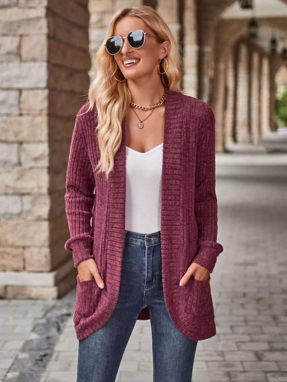 Open front ribbed knit cardigan in burgundy, featuring pockets, styled with a white top and sunglasses.
