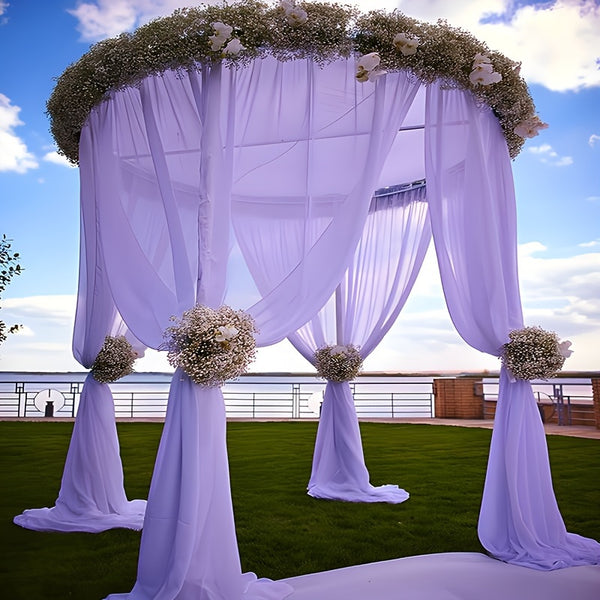 an outdoor wedding setup with white flowers and drapes