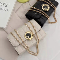 Elegant women's crossbody bags in black and white leather with decorative chains, perfect for luxurious weddings.