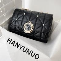 Stylish black quilted handbag with pearl accents and elegant clasp, perfect for luxurious weddings.