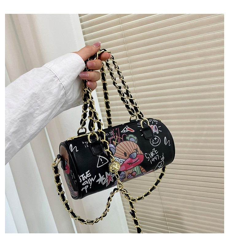Graffiti cylindrical leather zipper crossbody bag, perfect for luxurious weddings, with cartoon style and distinctive chain strap.