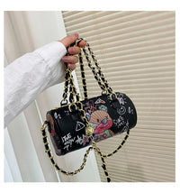 Graffiti cylindrical leather zipper crossbody bag, perfect for luxurious weddings, with cartoon style and distinctive chain strap.