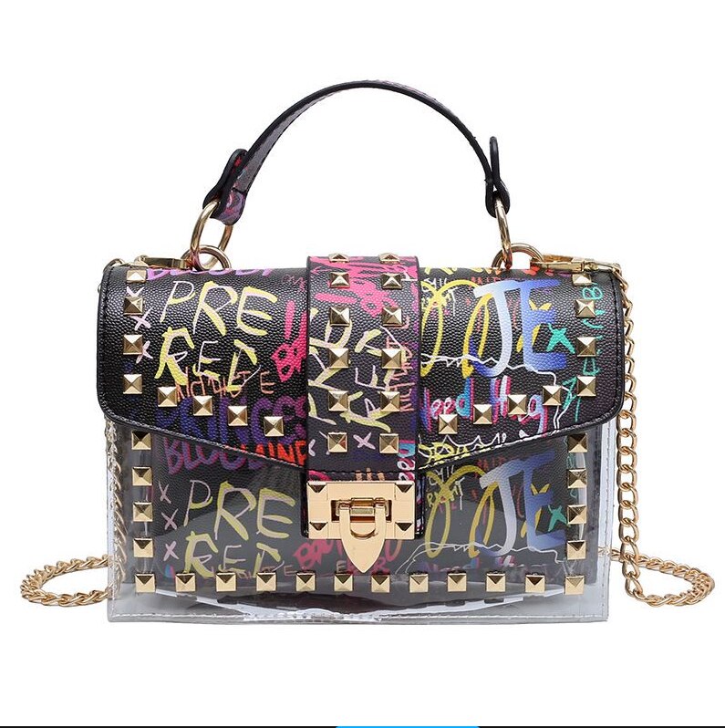 Colorful embellished handbag with graffiti print, gold studs, and a stylish chain strap for modern elegance.