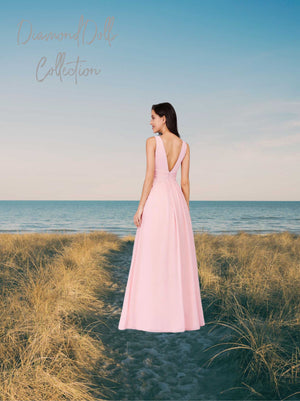 a woman in a pink dress standing on a beach