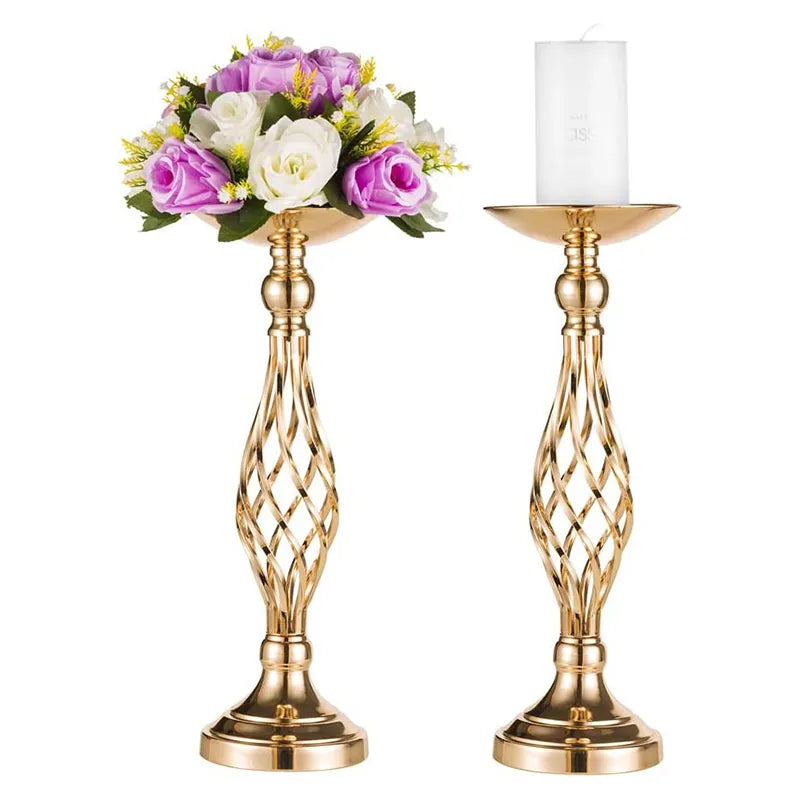 two gold candlesticks with flowers and a white candle
