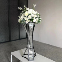 a metal vase with white flowers on a table