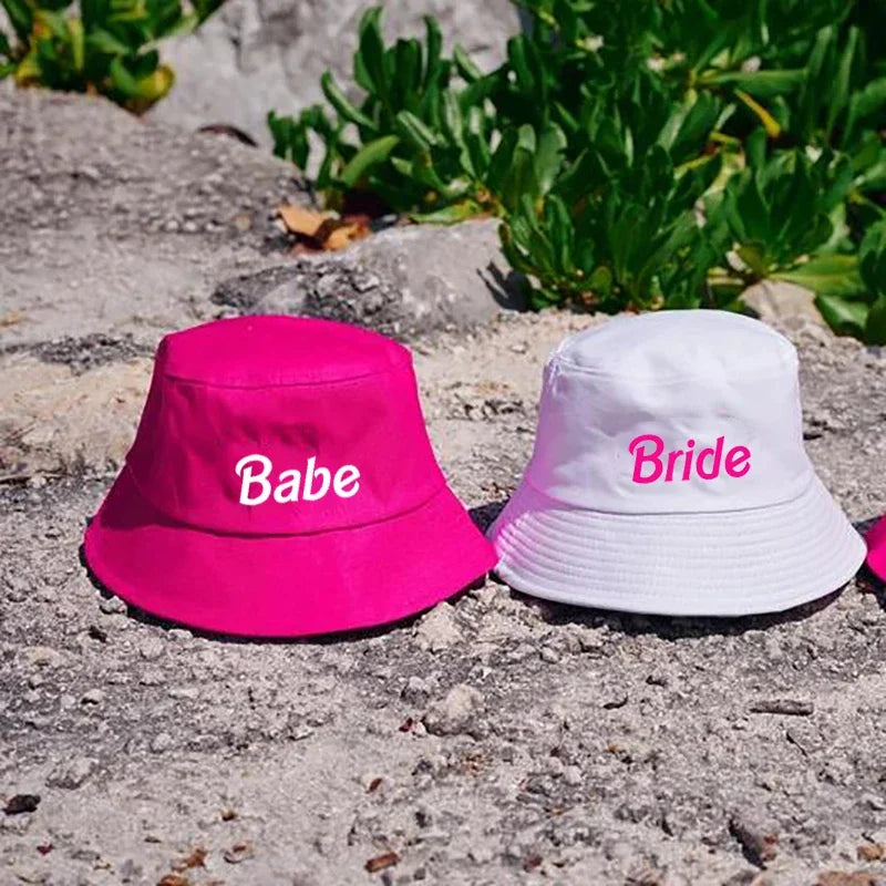 Hot pink 'Babe' and white 'Bride' bucket hats for bachelorette celebrations, embodying fun and festivity.