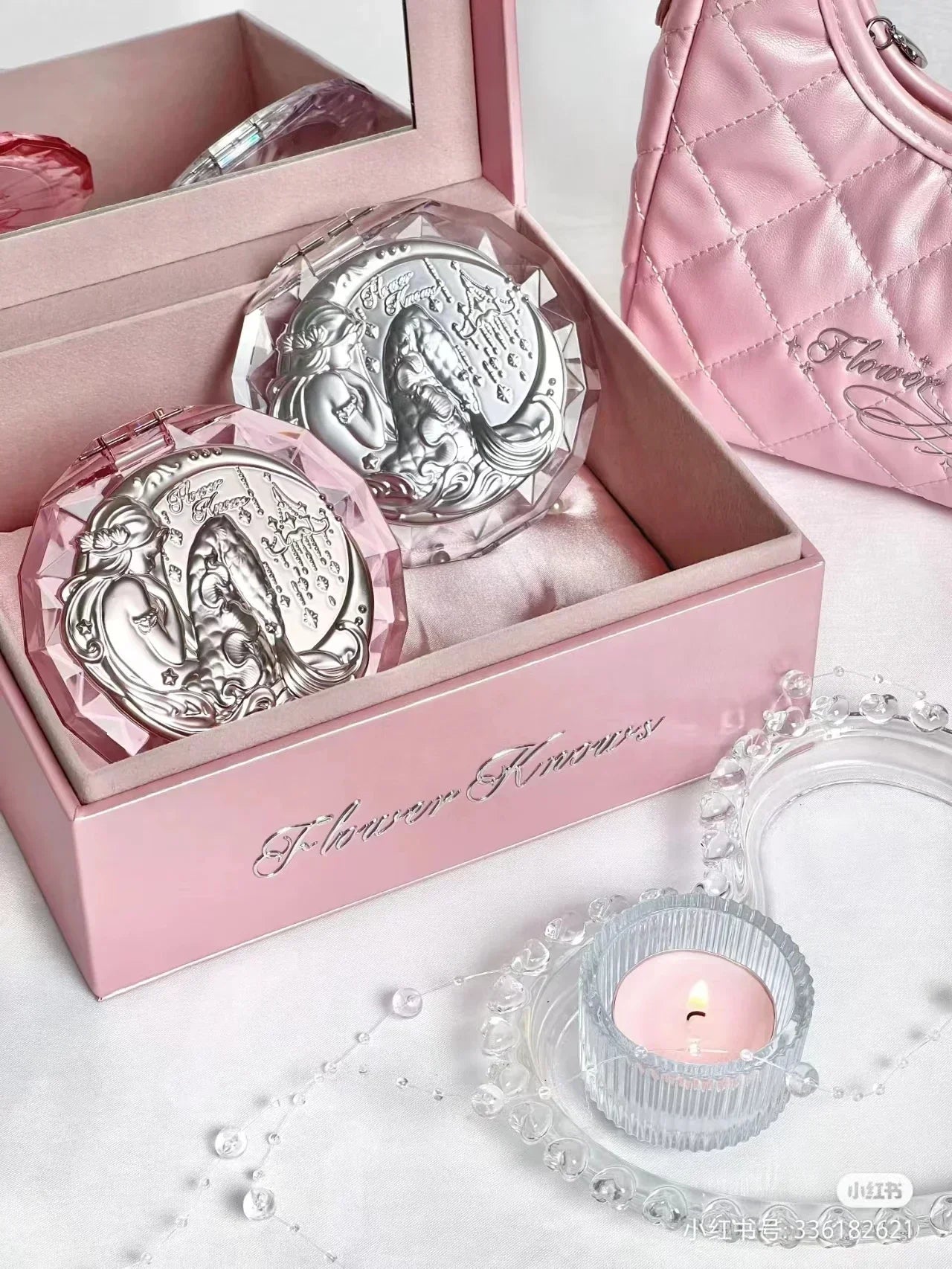 a pink purse and two silver coin sets in a pink box