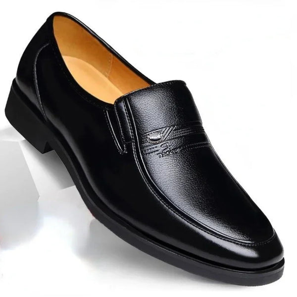 a pair of black shoes on a white surface