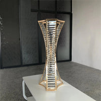 a tall metal sculpture sitting on top of a white table