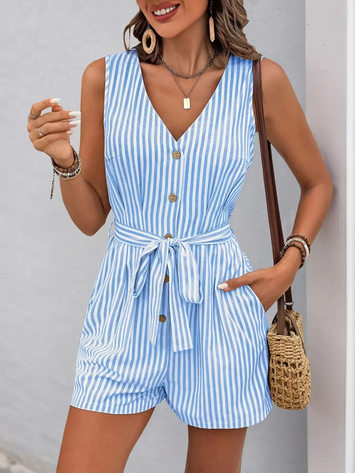 Striped V-neck belted romper in blue and white, featuring button front and practical pockets, perfect for summer style.