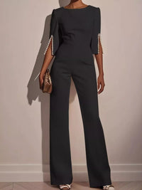 Wide-Leg Jumpsuit with Slit Sleeve in dark color with pearl detailing on sleeves.