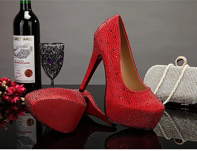 a pair of red high heels next to a bottle of wine