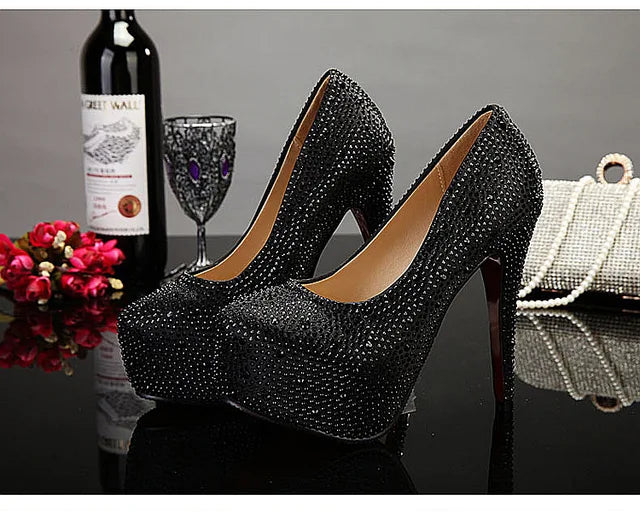 a pair of black high heels sitting next to a bottle of wine