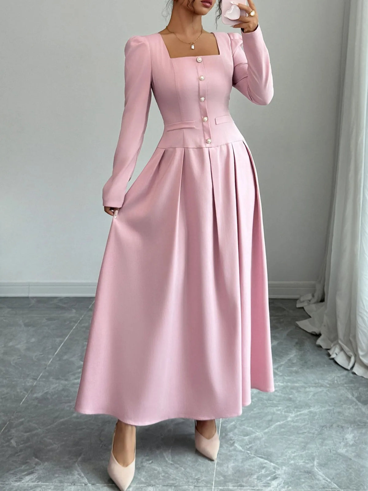 Square neck long sleeve maxi dress in soft pink with decorative buttons and flowing skirt.