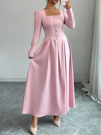Square neck long sleeve maxi dress in soft pink with decorative buttons and flowing skirt.